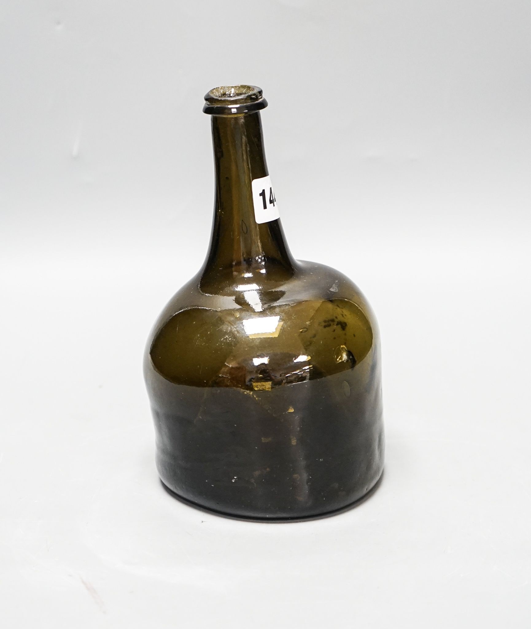 An English dark green glass ‘mallet’ wine bottle, c.1740, 21cm high